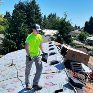 A handyman from Love Anchor Construction LLC installing roofing underlayment on a residential roof in Vancouver, WA.
