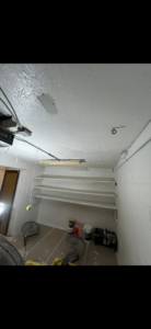 Handyman installing white shelves and painting walls in a room, a service by Midwest Painting & Contracting in Powell, OH.