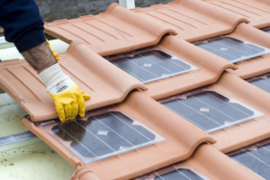 A handyman installing innovative solar roof tiles for a client of 1st Service Environmental Technologies in Pueblo, CO.