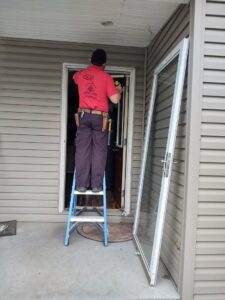 A handyman from IFixdIt Handyman Services in Omaha, NE, installing a new storm door on a residential entryway.