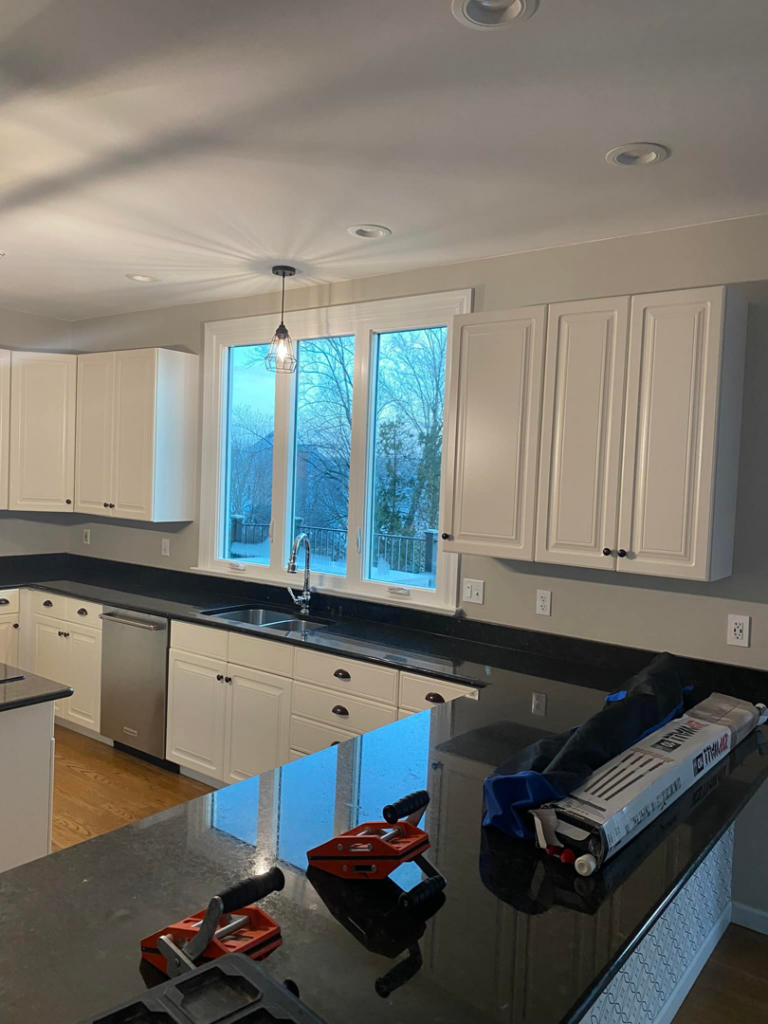 Handyman tools on a black kitchen countertop during cabinet and counter installation by CoCara Remodeling LLC in O Fallon, MO.