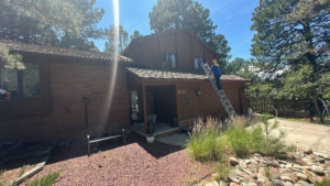 A handyman on a ladder performing repairs on the side of a house for Grayson General Contracting in Parker, CO.
