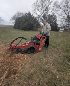 A handyman operating a stump grinder to remove a tree stump for The General Handyman in Los Angeles, CA.