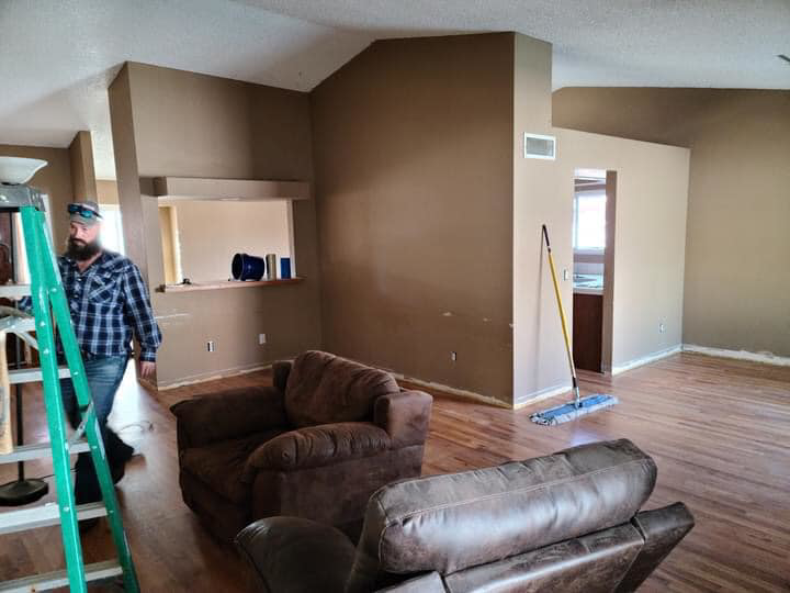 A handyman working on painting and renovating an interior room for Celano Construction in Mesa, AZ