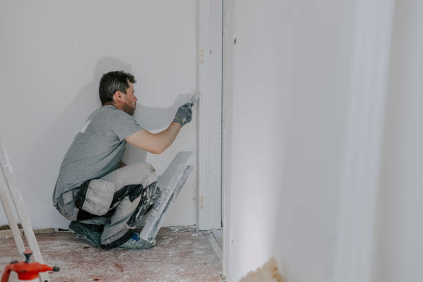 A handyman painting or spackling a wall and trim, a typical service provided by B&S Home Improvement in Evansville, IN.