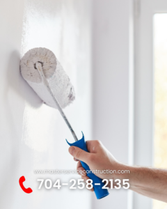 A handyman painting a wall with a roller for Master Service Construction Corporation General Contractor in Charlotte, NC