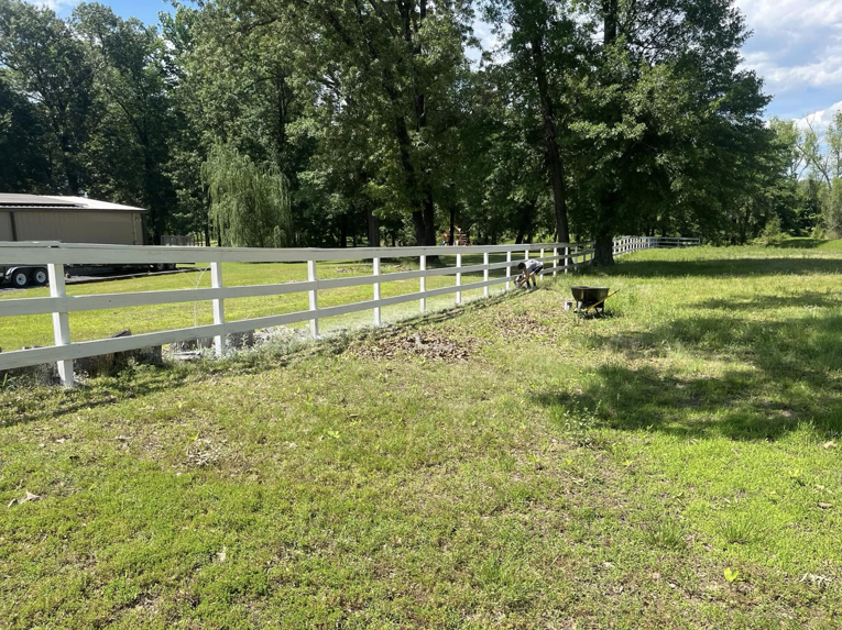 A handyman painting a white wooden fence for S&S Handyman Services in Reno, NV