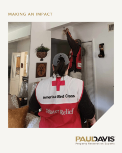 A handyman repairing a ceiling light fixture during a restoration job by Paul Davis Restoration of Charlotte, NC.