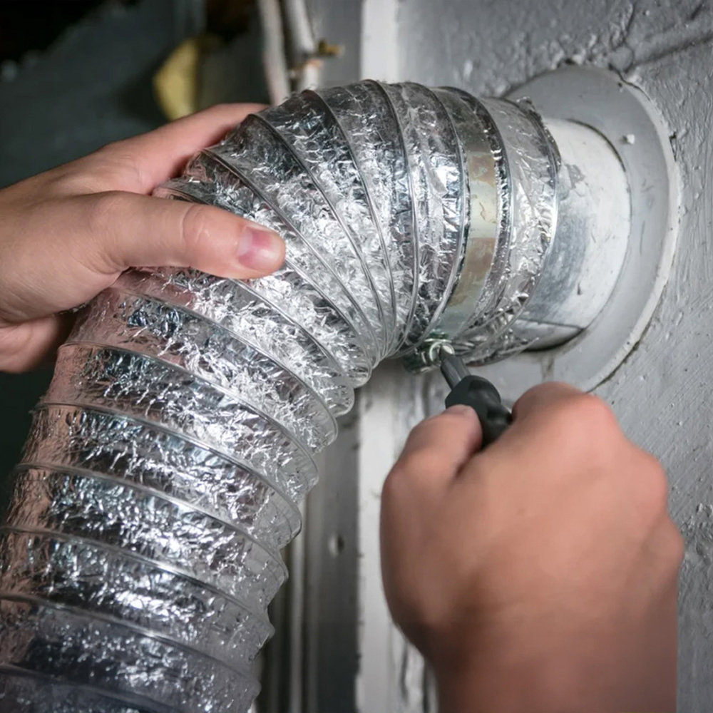A handyman repairing ductwork by attaching a flexible duct to a vent, a service by AC Services of Minden in Minden, LA.
