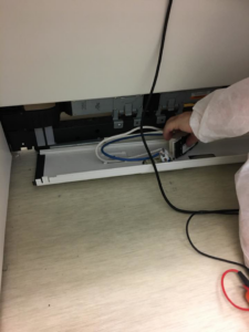 A handyman repairing or installing electrical wiring and cables under a counter for Master Handyman, LLC in Cleveland, OH.