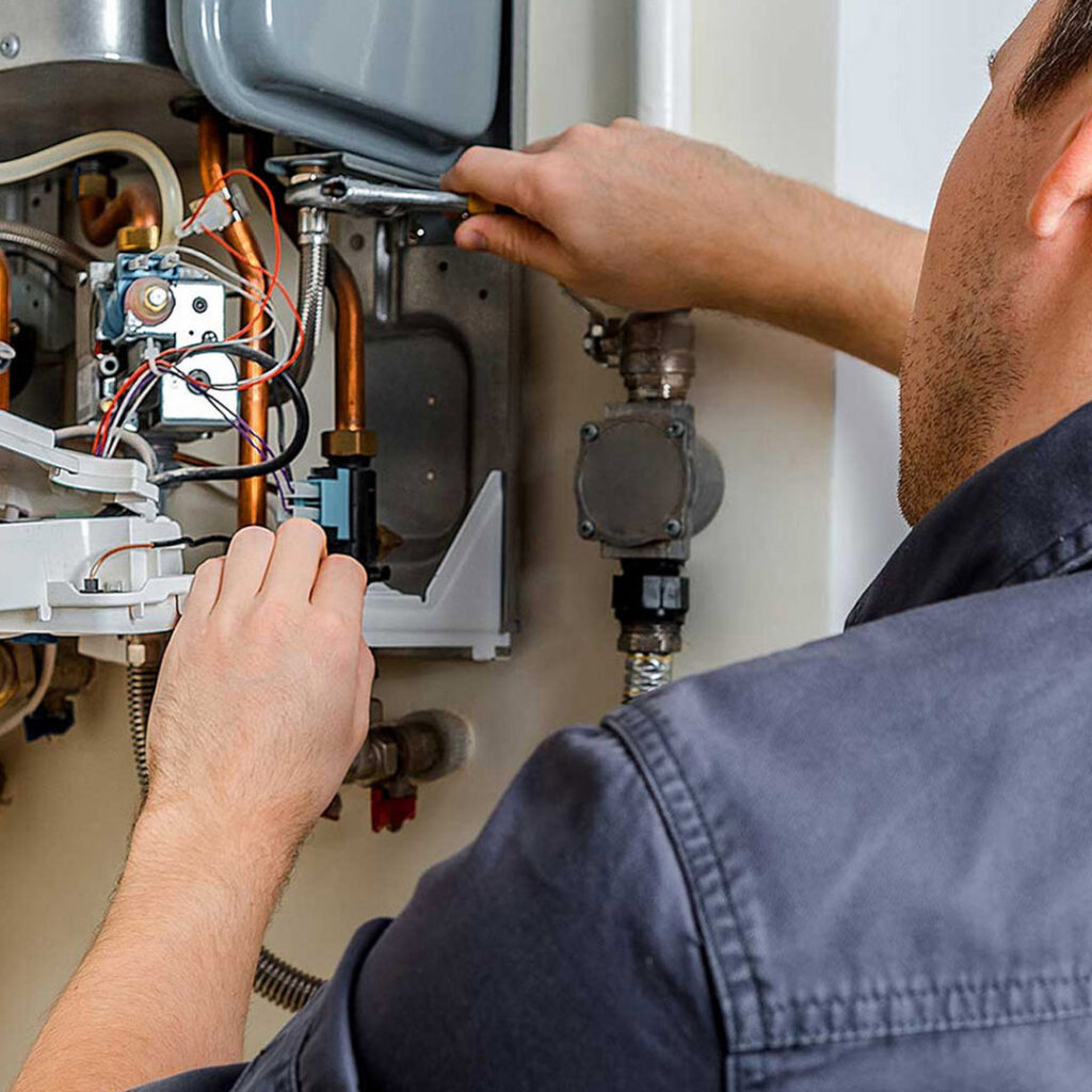 A handyman repairing a water heater or boiler, a common home repair service by AC Services of Minden in Minden, LA.