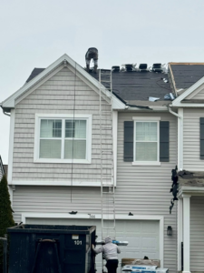 A handyman worker on a ladder replacing a roof for Darby Builders in Columbus, OH.
