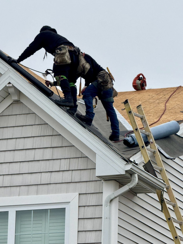 Two handyman crew members working on a roof repair project for Darby Builders in Columbus, OH.