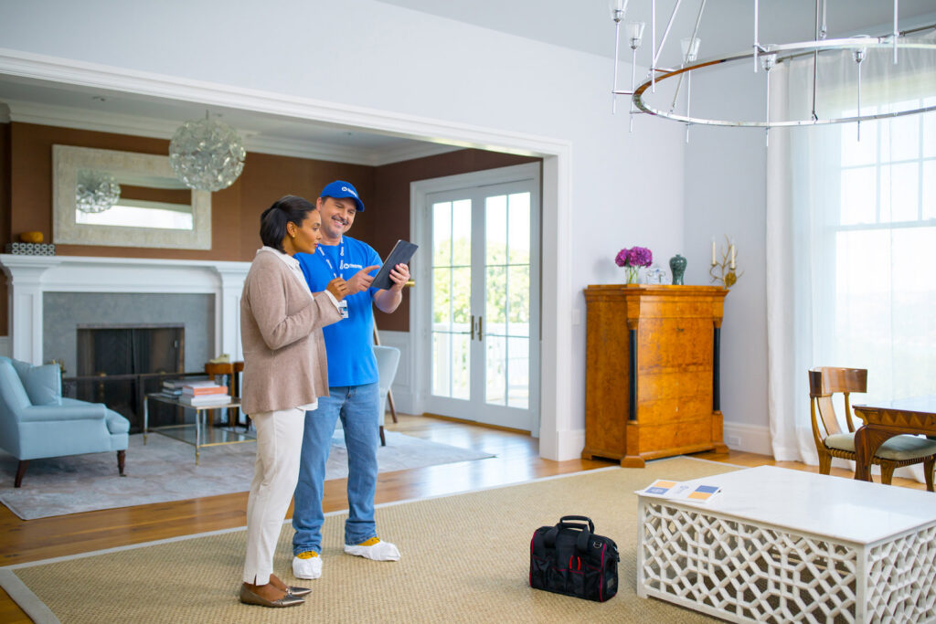 A Handyman Connection of Wichita East professional shows a tablet to a client in Wichita, KS.
