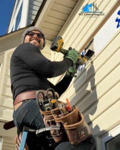 A handyman from MT Contracting performing siding repair on a house in Virginia Beach, VA
