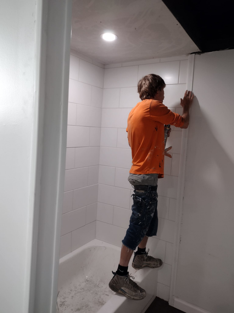 A handyman working on tiling a bathroom shower at a job site for I.B. Remodeling LLC in Dayton, OH.