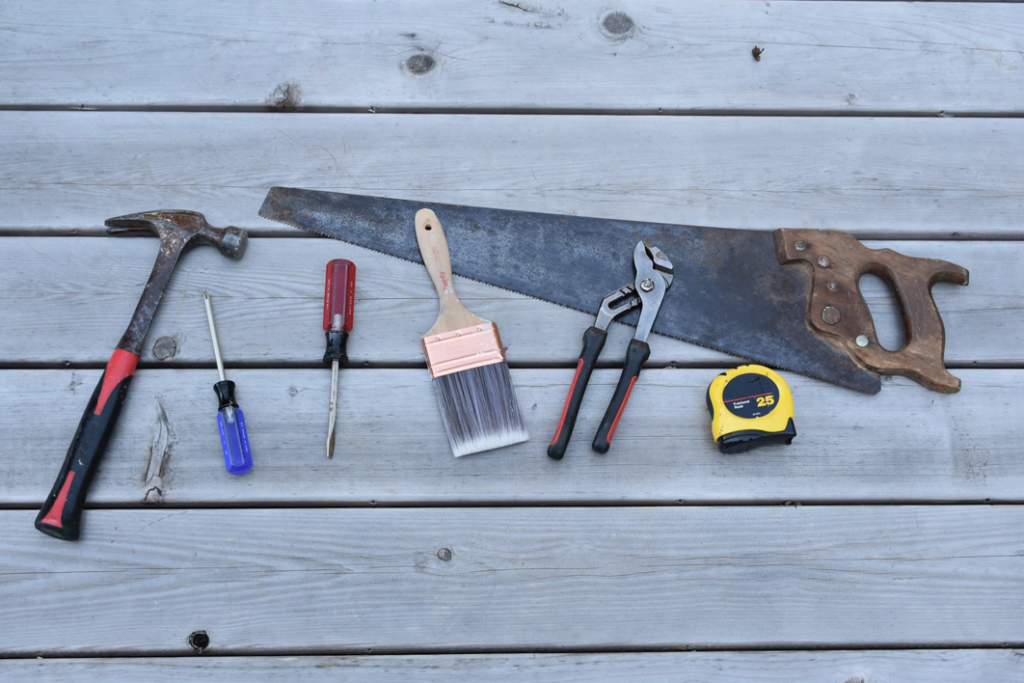 A collection of handyman tools on a wooden surface, representing services by Casco Bay Construction Services, LLC in South Portland, ME.