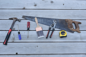 A collection of handyman tools on a wooden surface, representing services by Casco Bay Construction Services, LLC in South Portland, ME.