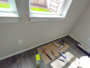 Handyman tools laid out on the floor, ready for trim installation and caulking by JJU Property Maintenance, LLC in Salem, OR.