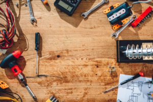A collection of handyman tools, including screwdrivers, wrenches, and wires, on a workbench for Advanced Mechanical Contractors, Inc. in Nashville, TN.