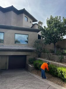 A handyman trimming bushes and performing landscaping services outside a home for Vegas Valley Remodeling/Handy-Man Services in Las Vegas, NV.