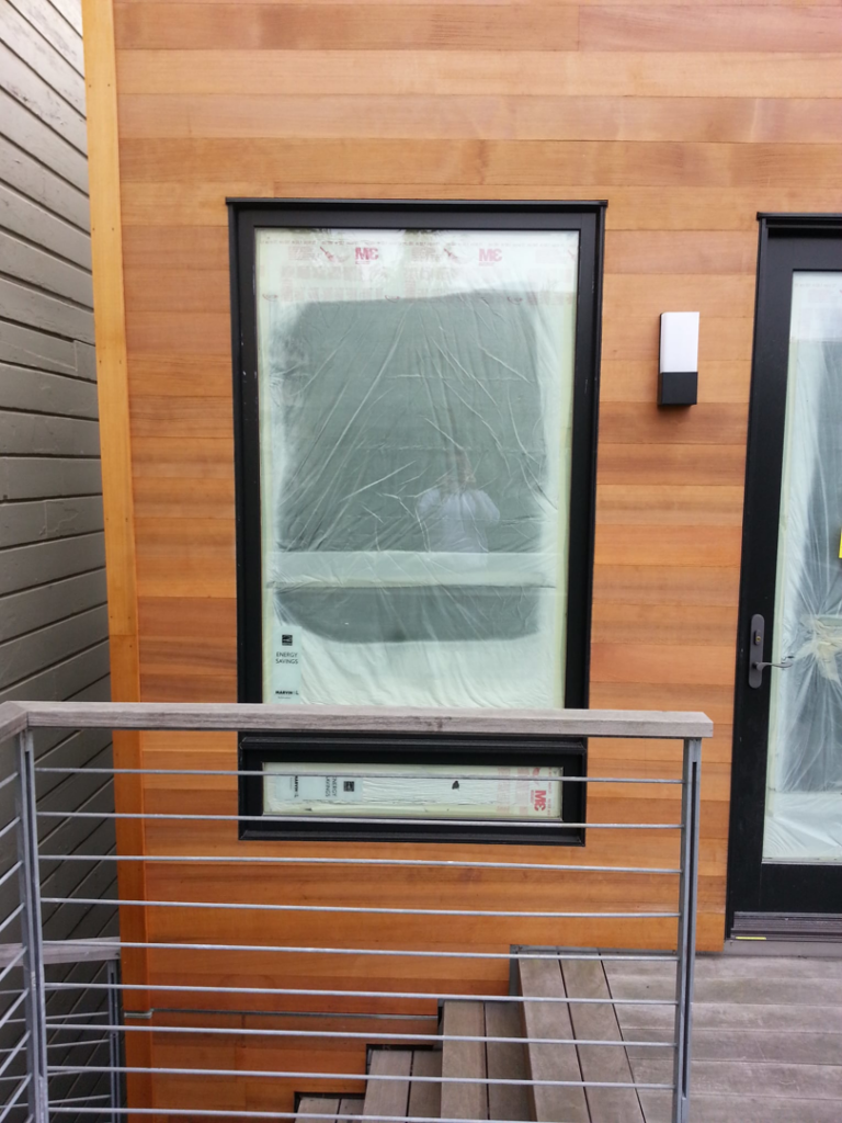 A newly installed window and wood siding on a building exterior by Tycon Builders Inc in San Francisco, CA