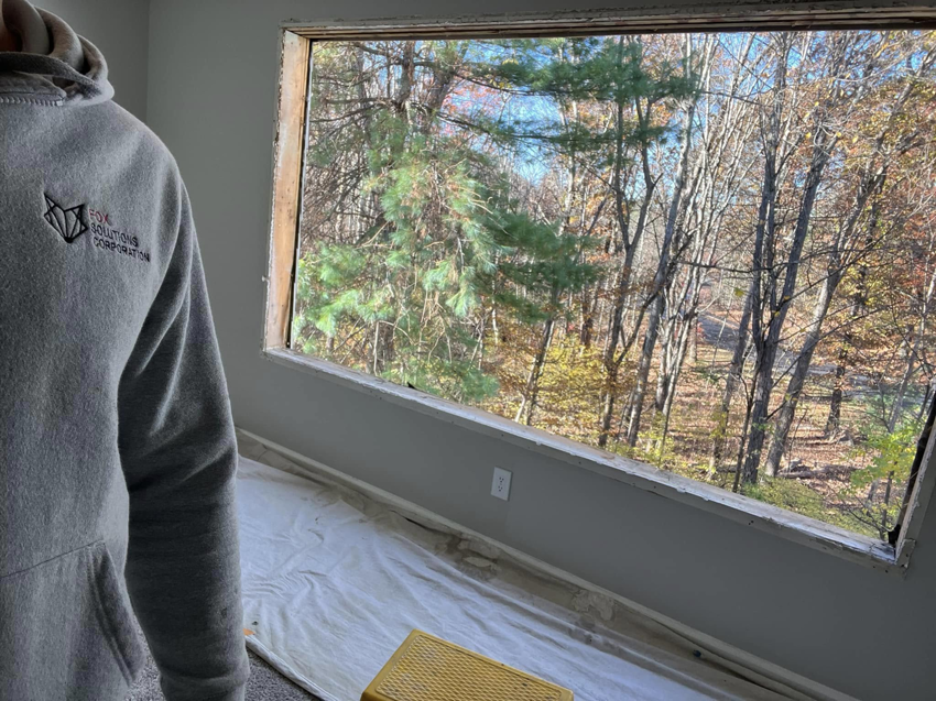 A handyman from Fox Solutions Corp overseeing a window replacement project in Worcester, MA