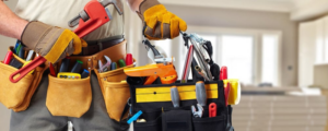 A handyman wearing work gloves and a tool belt, holding a pipe wrench for Lincoln Handyman Services in Lincoln, NE