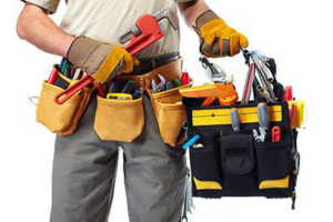 A handyman wearing a tool belt and gloves, holding a pipe wrench, ready for work with Waltz Contracting LLC in Bloomington, IN