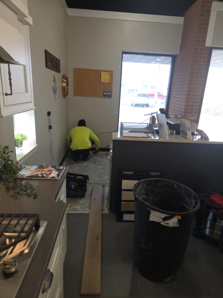 A handyman worker installing new flooring at Carpet Hut by McDrake in Virginia Beach, VA.