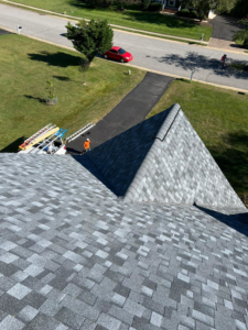 A handyman worker with ladders and equipment at a residential roofing job site by New American General Construction INC in Richmond, VA.