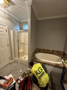 Handyman working on a bathroom remodel with new tub and shower enclosure by KG Handyman & Remodeling in Vilonia, AR.