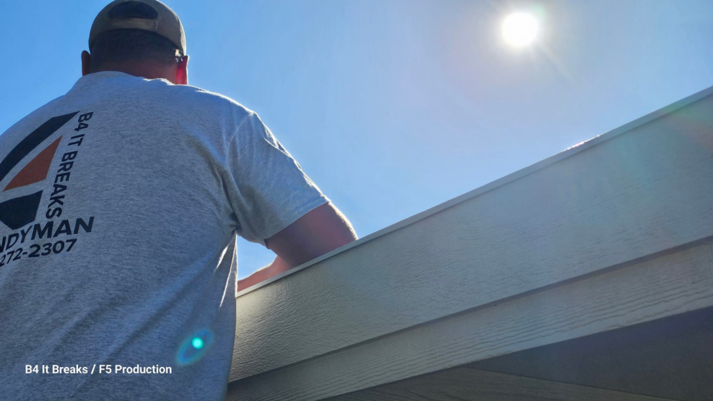 A handyman from B4 It Breaks working on the exterior of a building under a bright sun in Billings, MT.