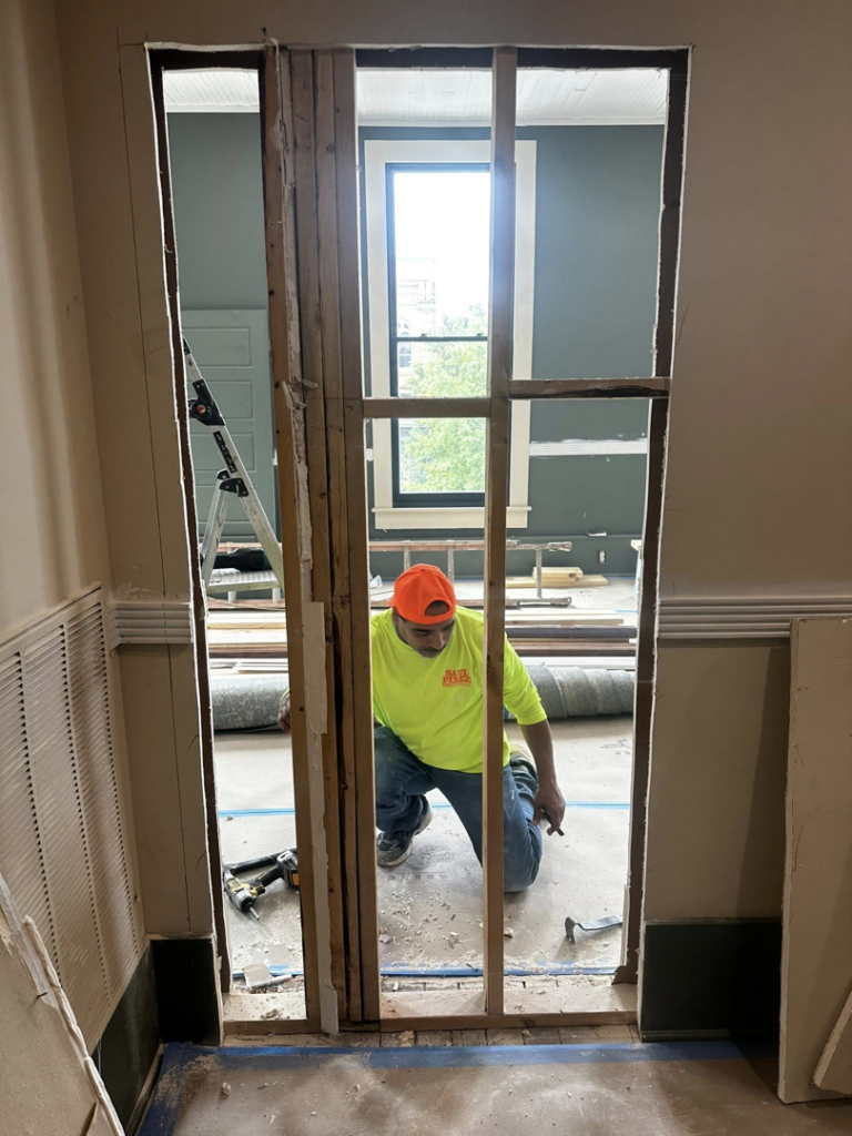 A handyman working on a door frame during a renovation project by Saul Perez Renovations LLC in Macon, GA.