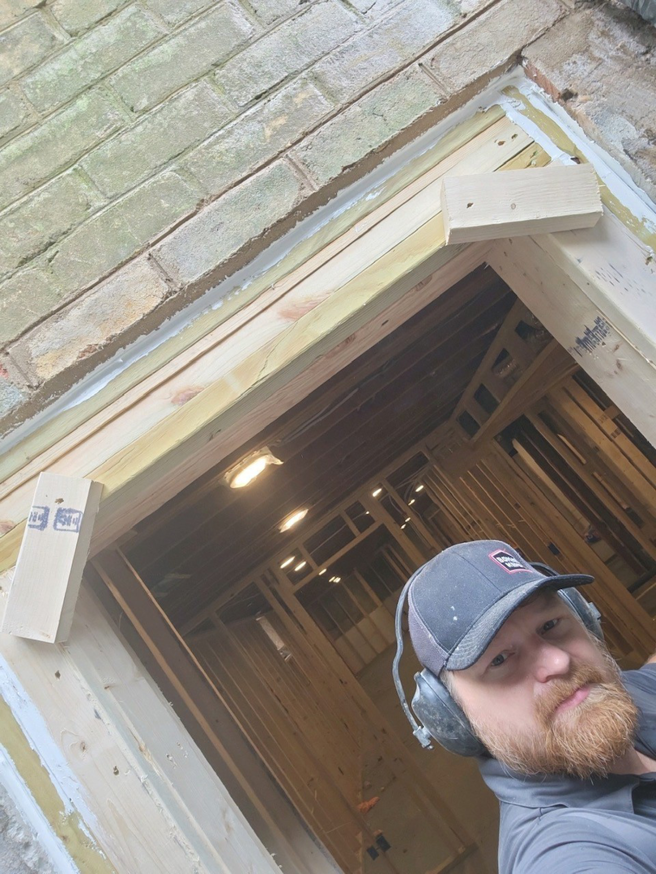 A handyman working on doorway framing during a home improvement project by JDS Home Improvement in Gaithersburg, MD.