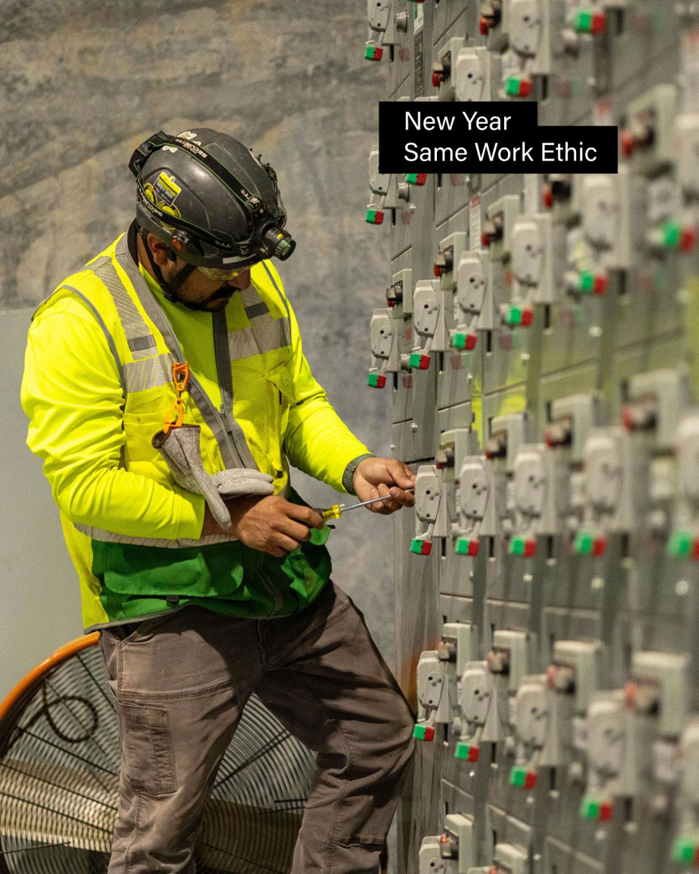 A handyman from M&L Electrical, Inc. working on a large electrical panel with a screwdriver in Bowling Green, KY.