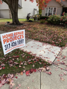 A handyman from Indiana Residential working on a home repair project in Indianapolis, IN, with a "Home Repair Projects" sign in the foreground.
