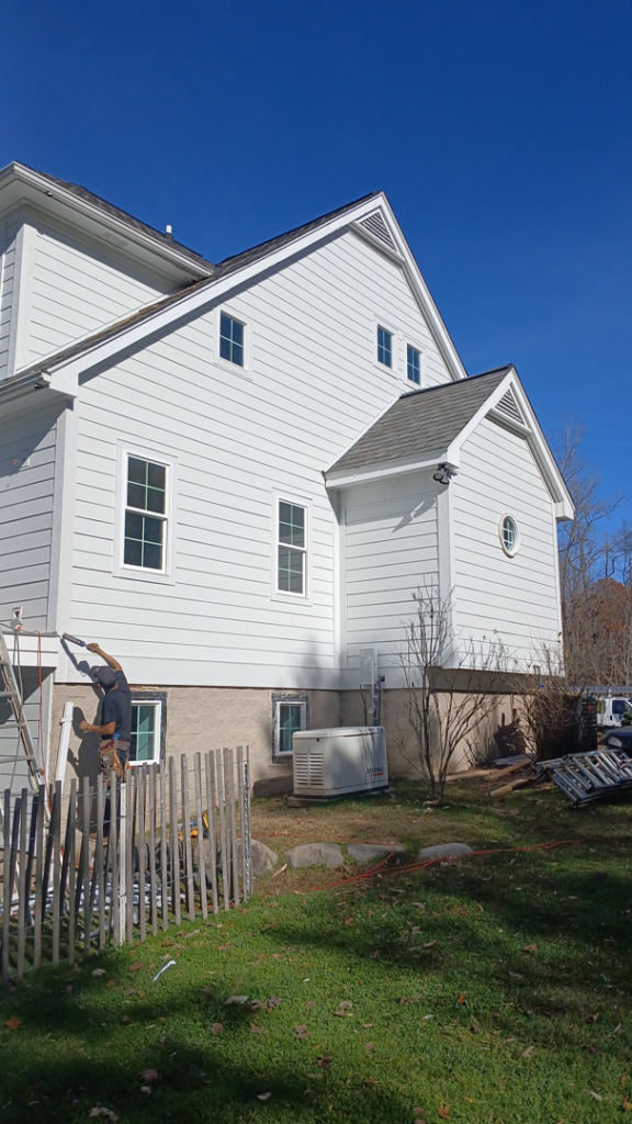A handyman working on the exterior of a house by Exterior Renovations, LLC in Clinton Township, MI.
