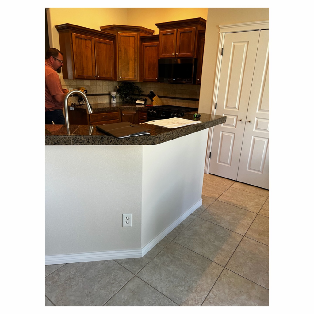 A handyman from Tom Broglia Building & Remodeling Services working on a kitchen sink installation in Boise, ID.