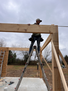 A handyman on a ladder installing wooden framing for a new structure by Classic Home Concepts in Springfield, MO