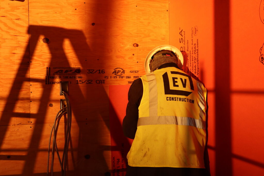 A handyman from EV Construction working on a wall with wiring installation at a job site in Holland, MI.