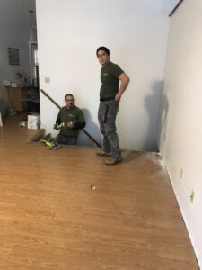 Two HandyVets professionals installing new flooring in a home in Saint Charles, MO.