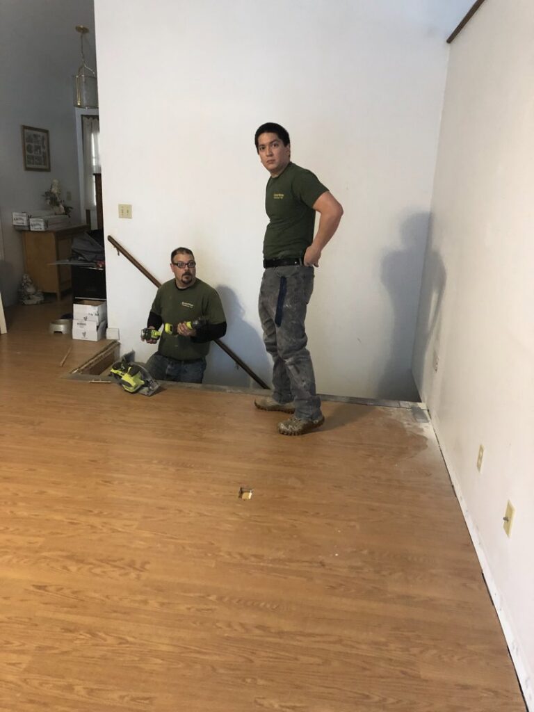 Two HandyVets professionals installing new flooring in a home in Saint Charles, MO.