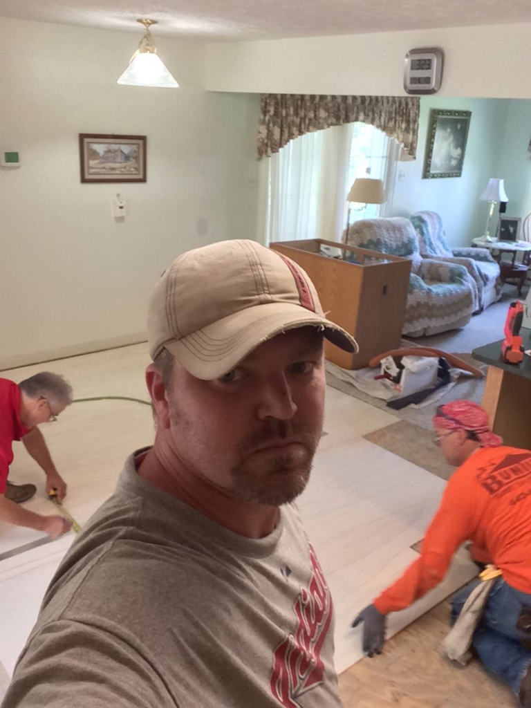 Handymen installing new flooring inside a home, a service by United Contractors of Maryland in Parkville, MD.