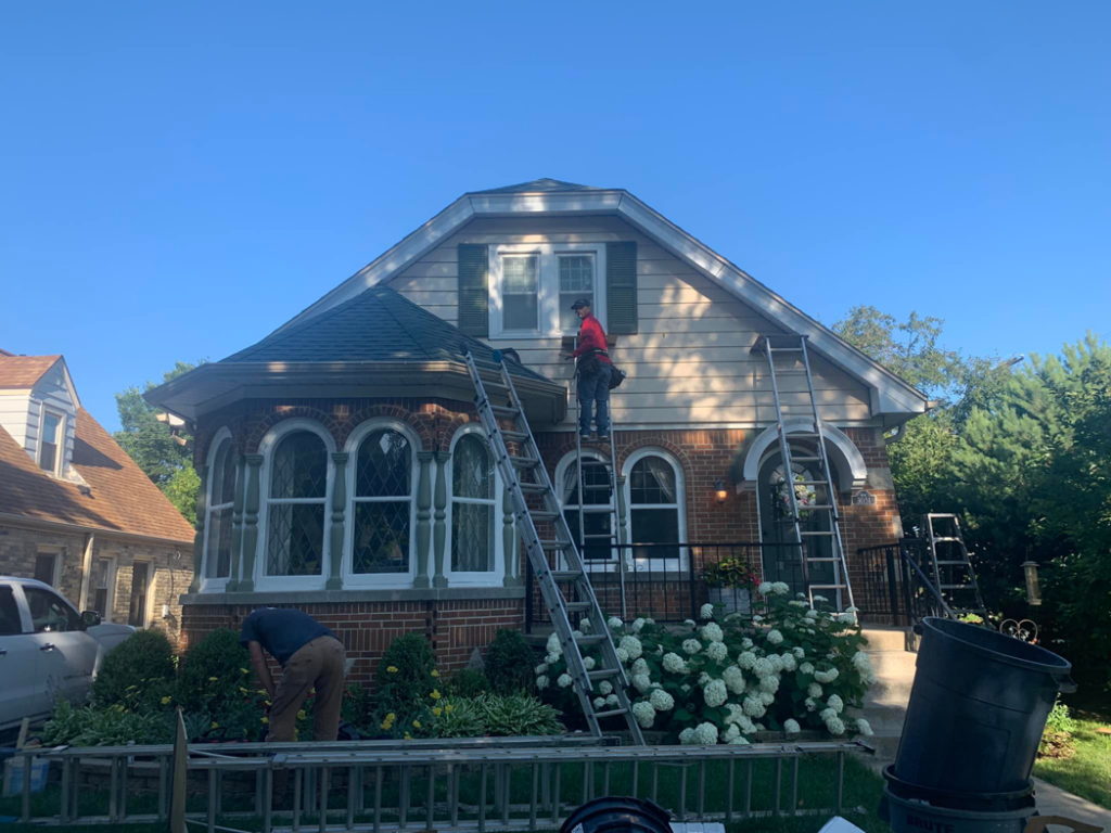 Handymen installing new siding on a house, a service provided by Sockett Siding, LLC in Milwaukee, WI