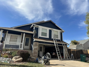 Handymen painting the exterior of a house with ladders and equipment for Froese's Creative Concepts & Luxury Designs LLC in Denver, CO.