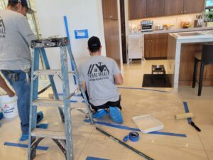 Two handymen from Vegas Handyman Services painting an interior wall in a kitchen area in Las Vegas, NV.