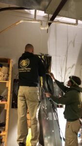 Two HandyVets technicians working on electrical wiring and HVAC systems in Saint Charles, MO.