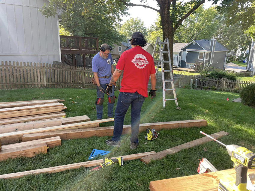 Two handymen working on a backyard construction project for Anderson and Son Services in Olathe, KS