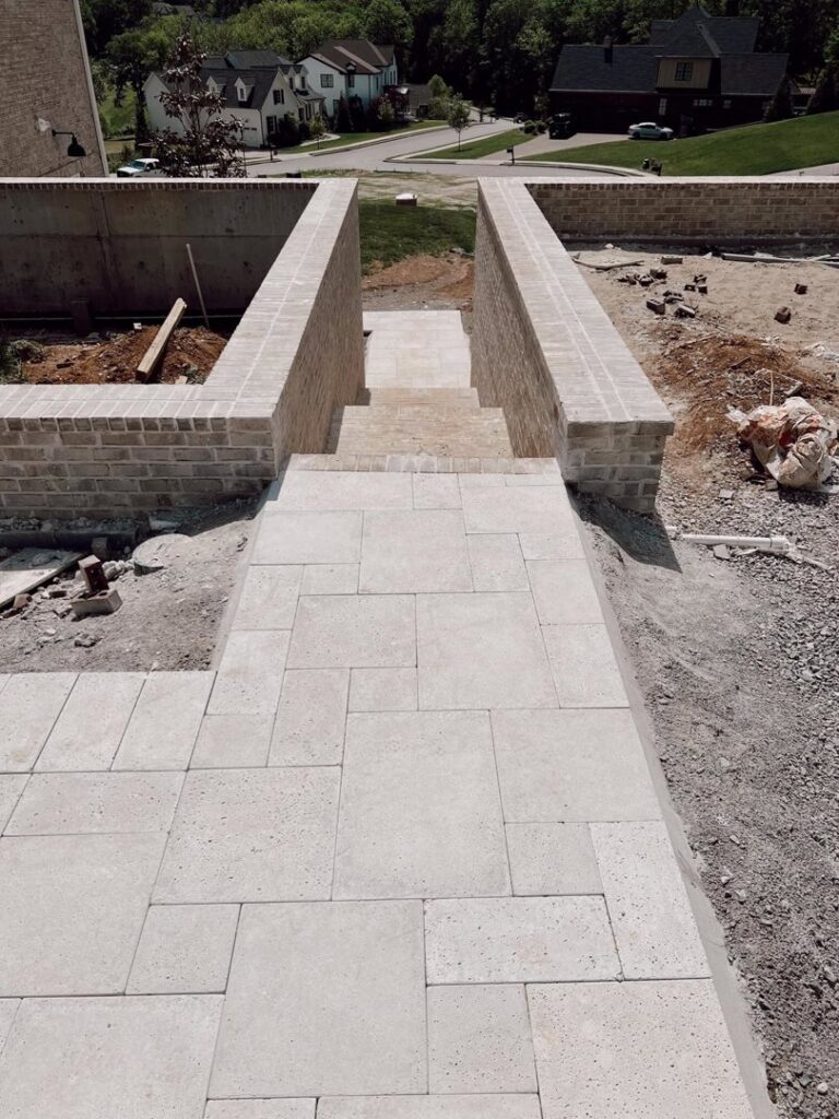 A hardscape pathway and steps under construction, featuring brick retaining walls, by Creative Pools and Hardscape in Franklin, TN.